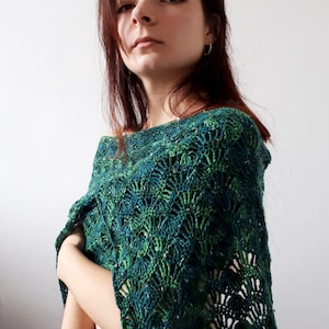 Może przedstawiać: Kobieta w zielono-niebieskim szalu na szyję wykonanym na szydełku z wzorem w kształcie wachlarza.