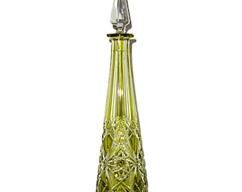 May include: A tall, green glass decanter with a clear glass stopper. The decanter has a diamond-shaped pattern etched into the glass.