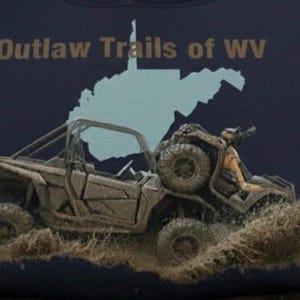 May include: Navy blue t-shirt featuring a graphic of an off-road vehicle splashing through mud. The text "Outlaw Trails of WV" is above a light blue outline of West Virginia.