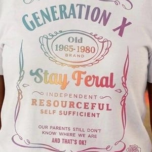 Könnte beinhalten: Weißes T-Shirt mit einem bunten Grafikdesign. Das Design enthält den Text "GENERATION X" und "Stay Feral" sowie zusätzlichen Text über Unabhängigkeit und Selbstständigkeit. Das Shirt hat einen Vintage-Look.