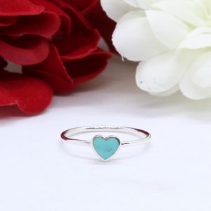 May include: A silver ring with a turquoise heart-shaped stone.