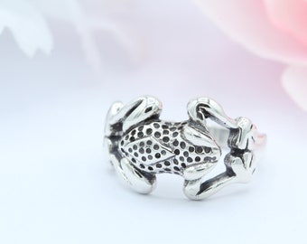 May include: A silver frog ring with a textured design. The frog is curled up with its legs crossed.