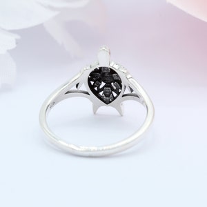 May include: A silver ring with a detailed turtle design. The turtle's shell is openwork and the ring is polished.