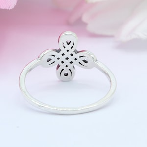 May include: A silver ring with a four-leaf clover design. The clover is detailed with intricate knotwork.