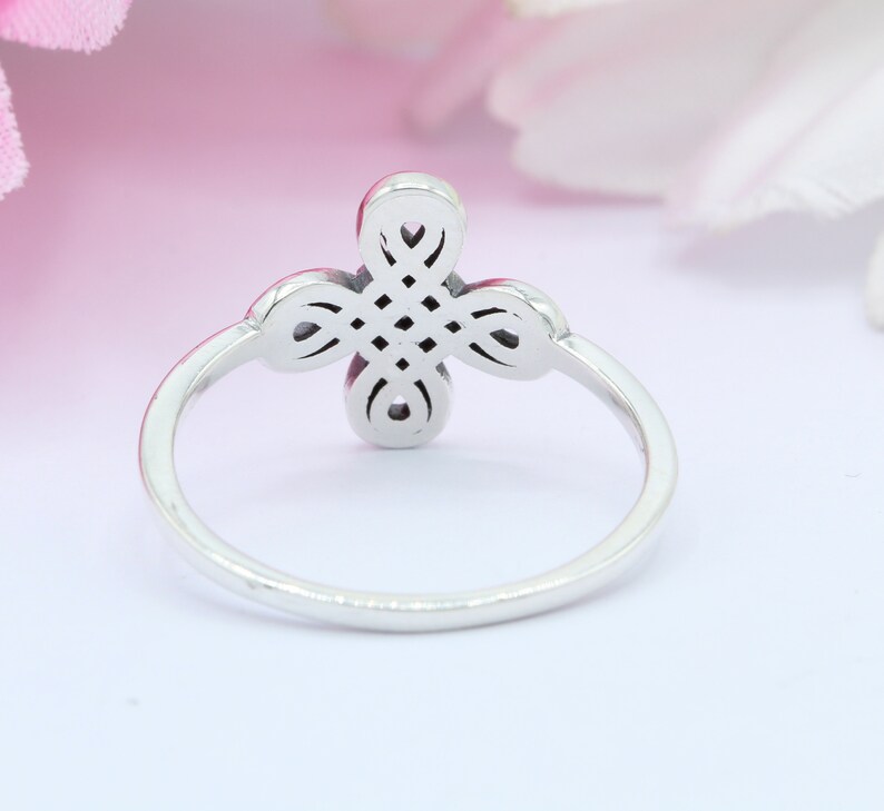 May include: A silver ring with a four-leaf clover design. The clover is detailed with intricate knotwork.