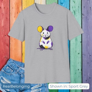 May include: Sport grey t-shirt with a cartoon mouse design. The mouse has yellow and purple ears, a white face, and a black and white body. The text "RealBelonging" is at the bottom left, and "Shown in: Sport Grey" is at the bottom right.