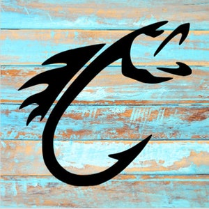 May include: Black silhouette of a fish hook on a blue and brown wooden background.