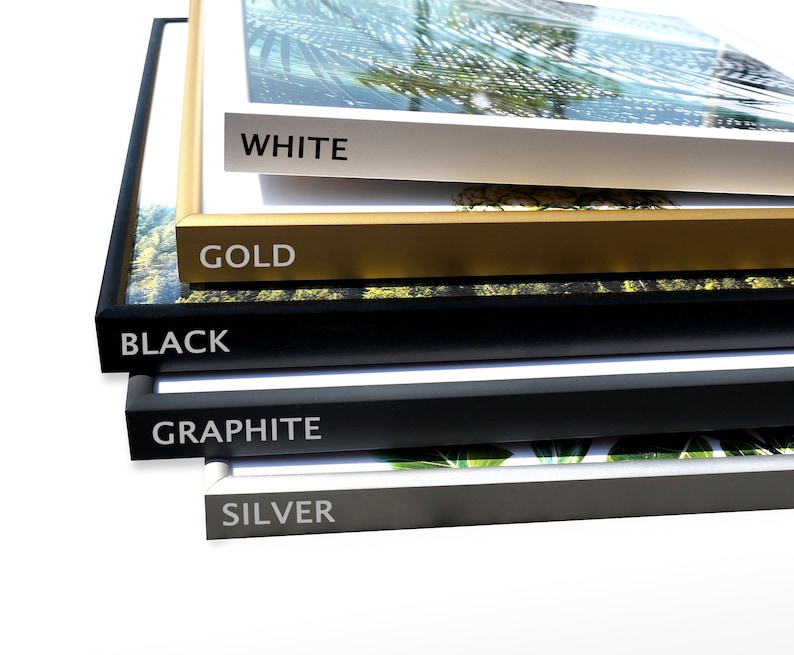 May include: Five picture frames stacked on top of each other. The frames are in different colors: white, gold, black, graphite, and silver. The frames are all the same size and shape.