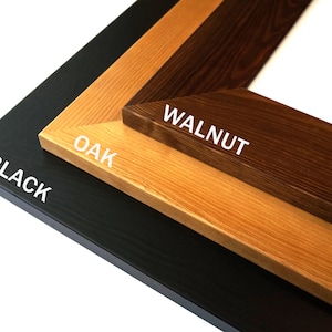 Puede incluir: Primer plano de tres muestras de marcos de fotos de madera: negro, roble y nogal. Se ven las esquinas de los marcos, con la veta de la madera y las variaciones de color claramente mostradas. Los textos "BLACK", "OAK" y "WALNUT" est&aacute;n impresos en cada marco.