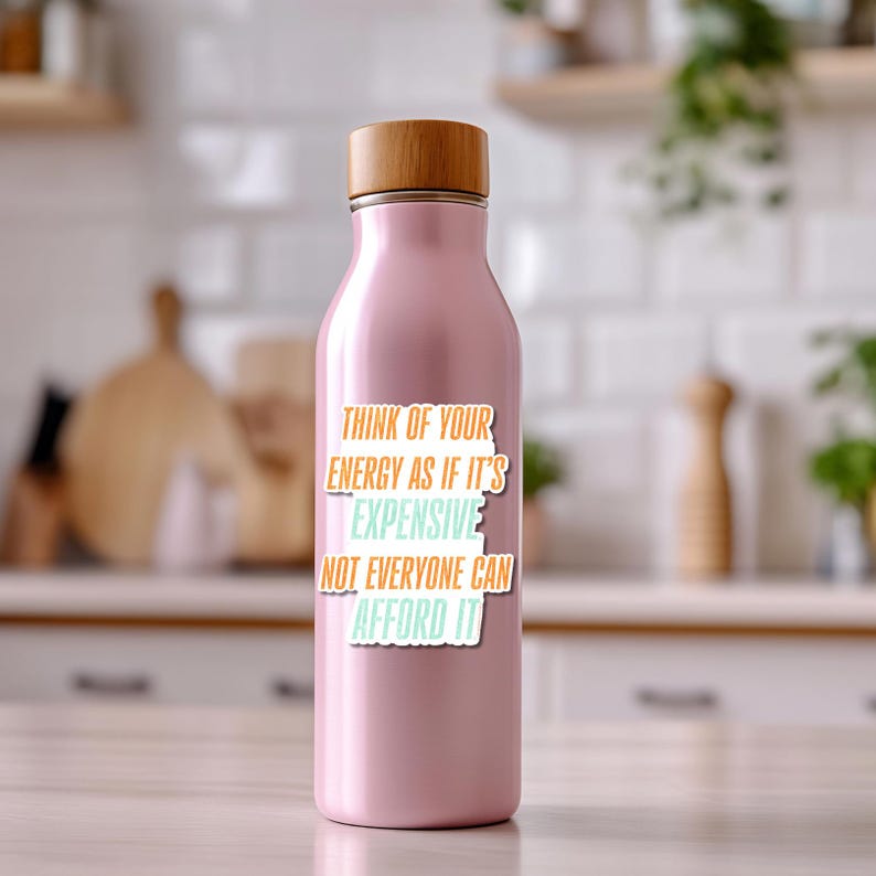 May include: A light pink insulated water bottle with a wooden lid. The bottle has the text "THINK OF YOUR ENERGY AS IF IT'S EXPENSIVE NOT EVERYONE CAN AFFORD IT" in orange, teal, and white.