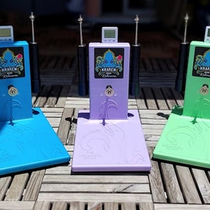 Op de afbeelding: Vijf kleurrijke elektronische apparaten met een digitaal display en een zwarte antenne. Elk apparaat heeft een basis in een andere kleur: roze, blauw, paars, groen en magenta. De apparaten hebben een afbeelding van een octopus met de tekst "Kraken" aan de voorkant.