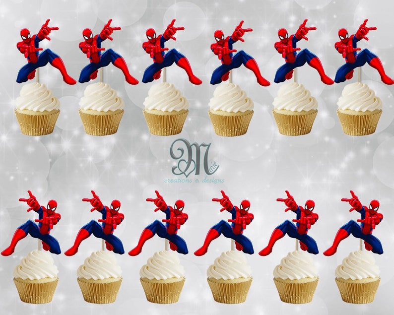 May include: Twelve red and blue Spiderman cupcake toppers on white frosted cupcakes. The cupcakes are on a white background.