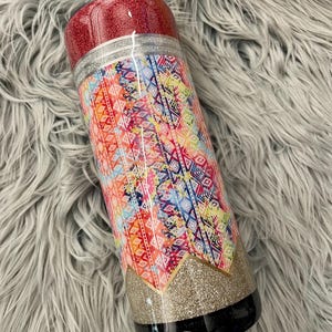 May include: A red, black and gold tumbler with a colourful geometric pattern. The tumbler has a glitter finish.