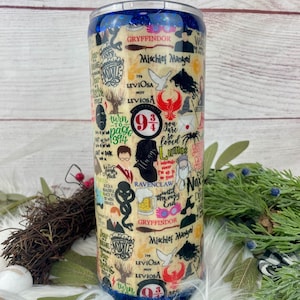 Puede incluir: Un vaso de acero inoxidable con un collage de gráficos y texto con temática de Harry Potter. El diseño incluye imágenes de las casas de Hogwarts, hechizos y personajes. El vaso tiene un borde azul brillante y un fondo beige.