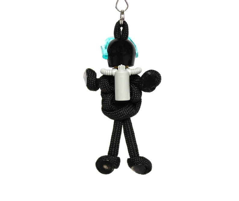 May include: Black paracord keychain with a black and white figure wearing a blue diving mask and a white oxygen tank.