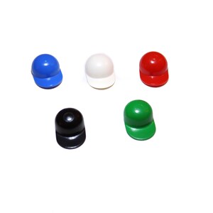 May include: Five miniature baseball caps in different colors: blue, white, red, black, and green.