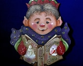 Hand painted Elf Christmas ornament, reading his snowman soup cookbook, hand painted in acrylic on wood, 5 by 4 inches, ribbon hanger