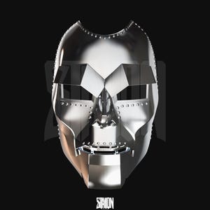 Può includere: Una maschera argentata metallica con un design geometrico, con dettagli rivettati e una forma angolare distintiva. La maschera ha aperture per gli occhi e un elemento nasale prominente, su sfondo nero. La parola "STATION" è stampata in basso.