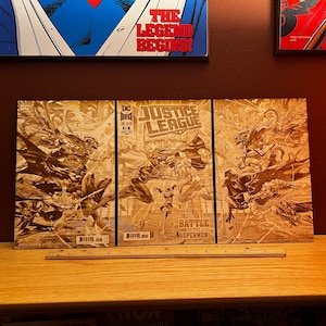 Puede incluir: Tres portadas de cómics con personajes de la Liga de la Justicia. Las portadas son marrones y tienen un tono sepia. La portada del medio dice "Justice League" y "Battle for Superman".