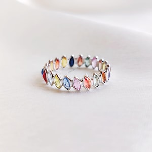 Anillo de oro blanco macizo de 14 quilates con múltiples zafiros naturales y banda de eternidad engastada en bisel.