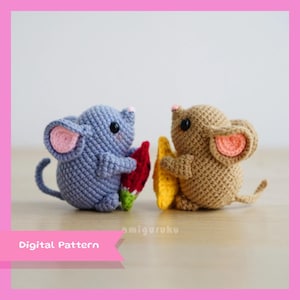 May include: Two crocheted mouse amigurumi toys holding fruit. The mouse on the left is blue and holding a watermelon slice. The mouse on the right is brown and holding a yellow star fruit.
