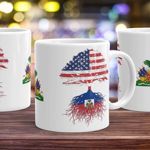 May include: Three white ceramic mugs with a tree design featuring the American flag and the Haitian flag. The tree trunk is the Haitian flag and the leaves are the American flag.