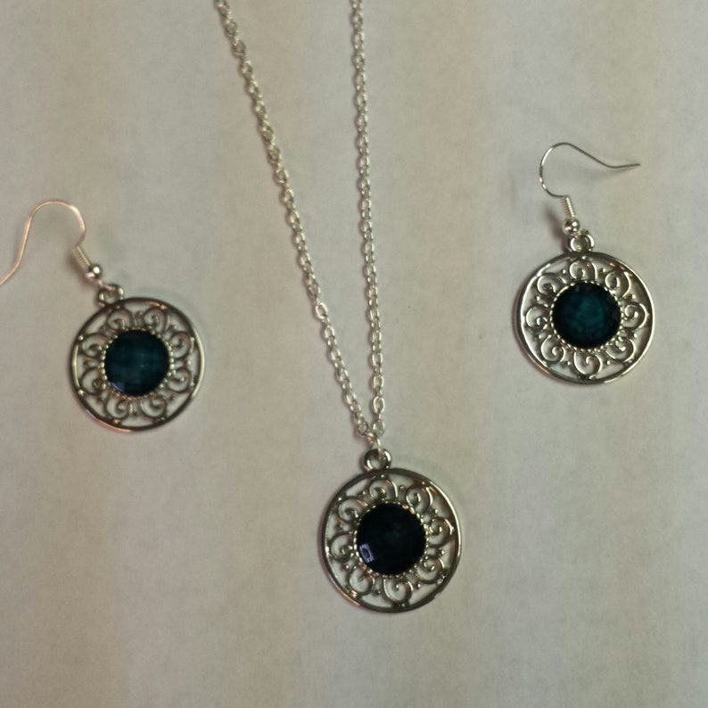 Blue-green center in silver filigree setting on necklace and earrings