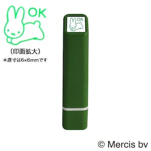 Pode incluir: Carimbo autoentintador verde com uma impressão quadrada branca que apresenta um coelho de desenho animado e a palavra "OK". O carimbo mede 6 mm por 6 mm.