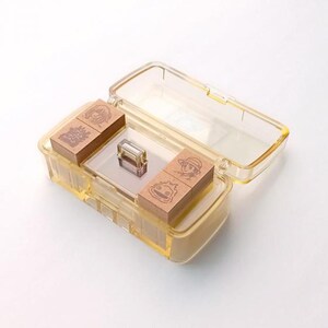 May include: A clear plastic case with four wooden stamps inside. The stamps feature illustrations of characters from the animated film "My Neighbor Totoro".