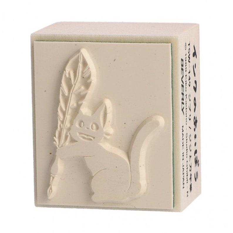 May include: A beige rubber stamp with a raised image of a cat holding a feather quill. The stamp is labeled "Ink of the Cat" and "TSW-149 Ghibli/Jiji and Fountain Pen".