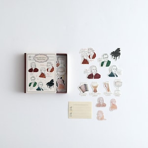 May include: A box of stickers featuring illustrations of famous composers and musical instruments. The box is brown with white text that reads "great book icons of Musicology". The stickers are on a white background and include images of composers such as Bach, Beethoven, Mozart, and Chopin, as well as instruments such as a piano, a drum, and a violin.