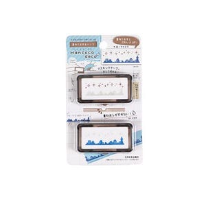 Pode incluir: Duas pequenas caixas de plástico castanho com tampas transparentes. Cada caixa contém um dispensador de fita adesiva branco com um design decorativo. A caixa superior tem um design rosa e branco com estrelas e uma cidade. A caixa inferior tem um design azul e branco com uma cidade. O texto na embalagem diz "Hancoco deco" e "重ねておすと かわいさUP!"