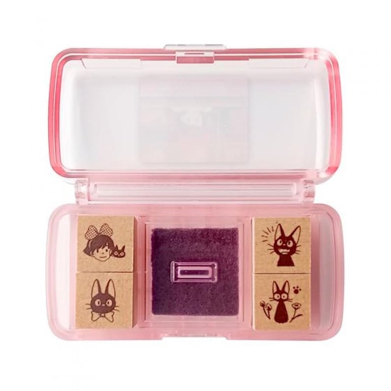 May include: A pink plastic case with four wooden stamps featuring characters from the animated film Kiki's Delivery Service. The stamps are in a clear plastic case with a purple ink pad.