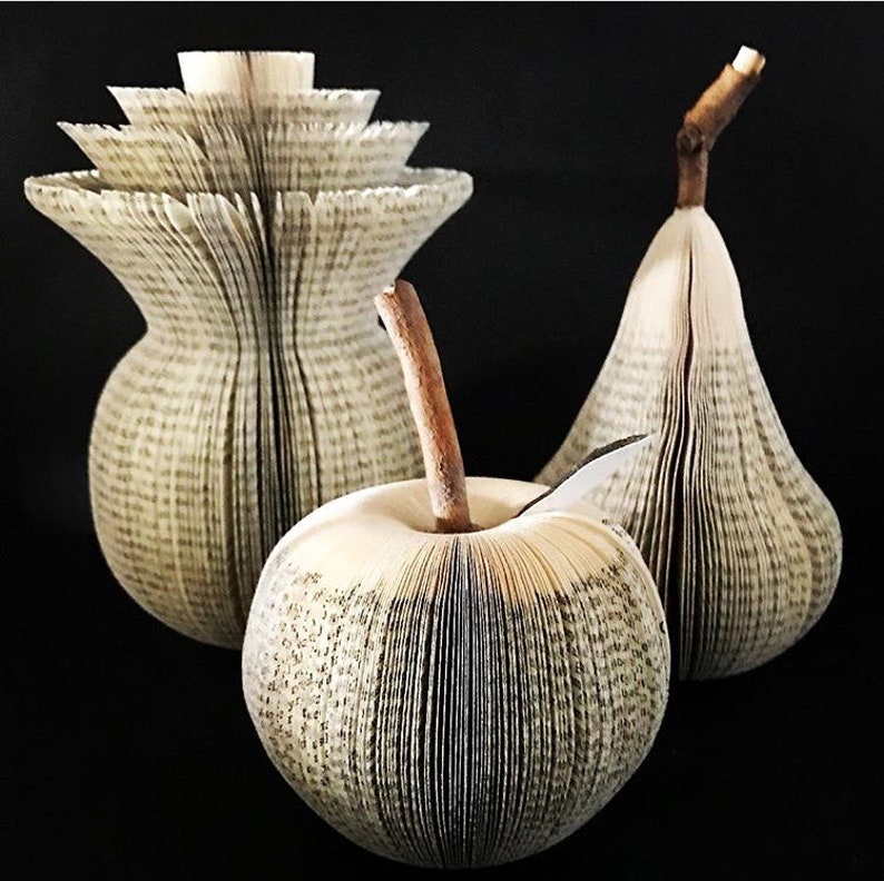 Sculptural apples and pears made from recycled books. A real branch is used for their stems.