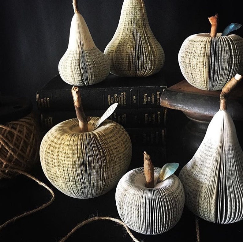 Sculptural apples and pears made from recycled books. A real branch is used for their stems.