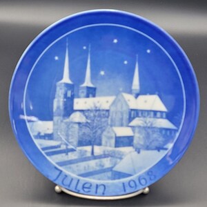 May include: A blue and white Christmas plate with a snowy church scene and the text "Julen 1968".
