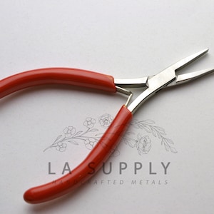 Puede incluir: Alicates de punta fina con mango rojo y cabeza de metal plateado. Los alicates tienen una punta puntiaguda y se utilizan para la fabricaci&oacute;n de joyas.