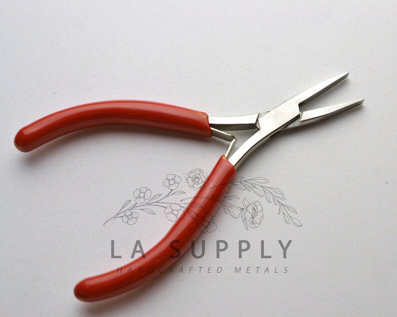 Puede incluir: Alicates de punta fina con mango rojo y cabeza de metal plateado. Los alicates tienen una punta puntiaguda y se utilizan para la fabricaci&oacute;n de joyas.
