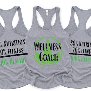 May include: Three gray tank tops with a wellness theme. The center tank top has a green circle with a leaf and the text "Wellness Coach". The left and right tank tops have the text "80% Nutrition 20% Fitness 100% Healthy".