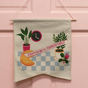 May include: A white canvas banner with the text "Everything is Figureoutable" hanging on a pink door. The banner features a fortune cookie, two potted plants, and a clock.