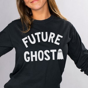 May include: A black long-sleeved shirt with white text that reads "FUTURE GHOST" and a white ghost graphic.