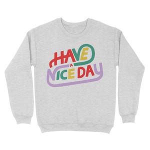 May include: A grey sweatshirt with the text "HAVE A NICE DAY" in colourful, stylised lettering.