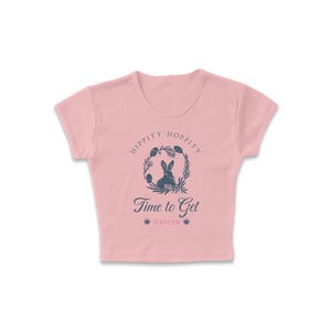 May include: A pink cropped t-shirt with a graphic of a bunny rabbit inside a wreath with the text "Hippity Hoppity Time to Get Zooted".