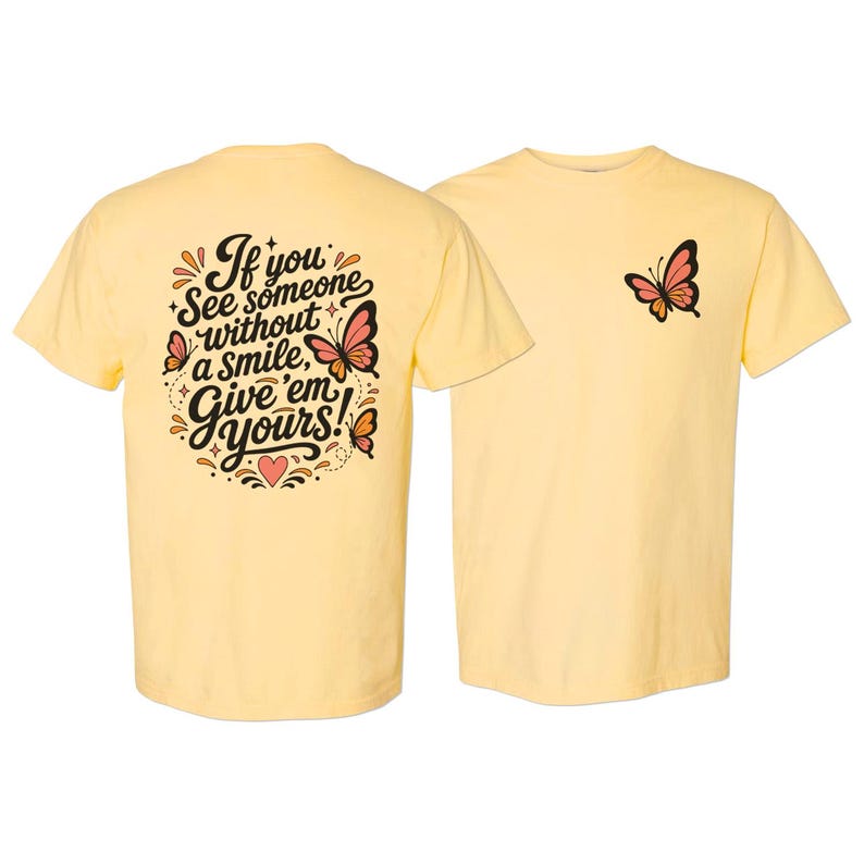 May include: A pale yellow t-shirt featuring a small butterfly graphic on the front left chest and a large back print with the text If you see someone without a smile, give 'em yours! surrounded by decorative butterflies, stars, and a heart.