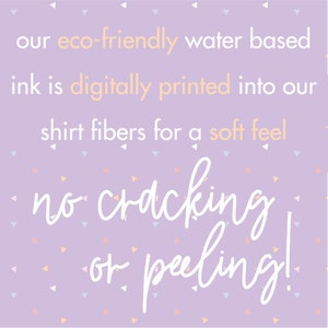 May include: A light purple background with small, colorful triangle shapes. Text in white and light orange states: "our eco-friendly water based ink is digitally printed into our shirt fibers for a soft feel. No cracking or peeling!"