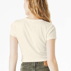 May include: A white cropped t-shirt with short sleeves and a crew neck.