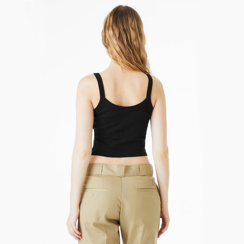 May include: A black tank top with wide straps. The top is cropped and form-fitting. The model is wearing khaki-colored pants. The background is plain white.