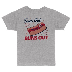 K&ouml;nnte beinhalten: Graues T-Shirt f&uuml;r Kinder mit einem Cartoon-Hotdog mit einem l&auml;chelnden Gesicht und dem Text "Suns Out, Buns Out".