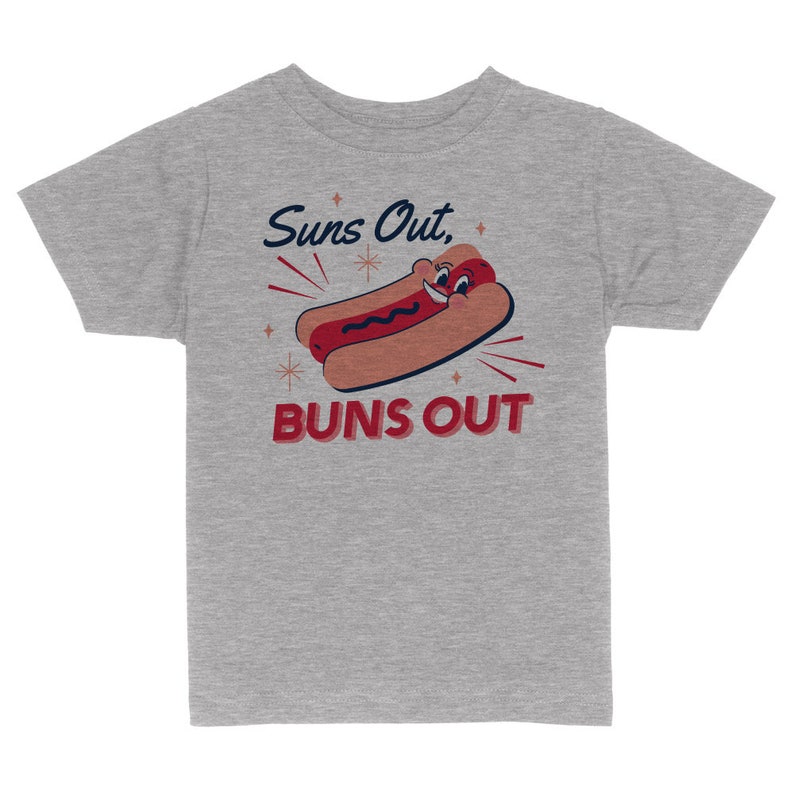 K&ouml;nnte beinhalten: Graues T-Shirt f&uuml;r Kinder mit einem Cartoon-Hotdog mit einem l&auml;chelnden Gesicht und dem Text "Suns Out, Buns Out".