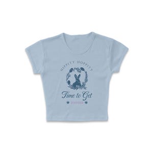 May include: Light blue cropped t-shirt with a graphic of a rabbit in a wreath with the text "Hippity Hoppity Time to Get Zooted".